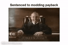 a judge is sitting at a desk in a courtroom holding a briefcase .