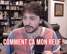 a man sitting in front of a microphone with the words comment ca mon reuf