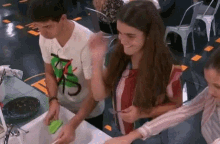 a man and a woman are washing dishes in a sink .