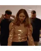 a woman in a sequined top is standing in a crowd