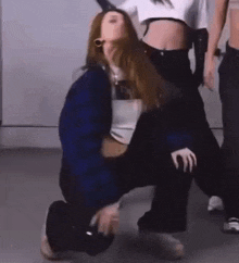 a woman is kneeling on another woman 's lap .