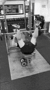 a black and white photo of a man lifting a barbell