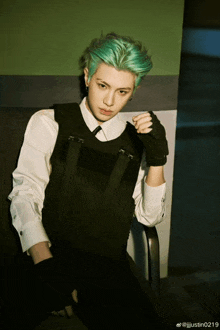 a man with green hair is wearing a white shirt and a black vest