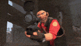 a man in a red shirt is holding a gun and looking through it