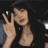 a girl with long black hair is giving a peace sign in korean