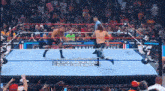 two wrestlers are in a wrestling ring with a sign that says wwe on it