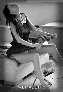 a black and white photo of a woman sitting on a couch next to a fan with the caption " we made it !!! "