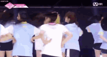 a group of people are standing in a circle and one of them is wearing a white shirt and shorts .
