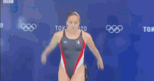 a woman in a bikini is jumping off a diving board in a swimming pool .