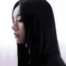 a close up of a woman 's face with long black hair against a white background