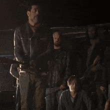 a man in a leather jacket is holding a sword