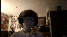 a person wearing headphones in a room with a poster on the wall that says ' peace ' on it