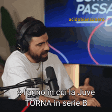 a man wearing headphones is talking into a microphone and the words torna in serie b are on the screen behind him