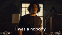 a man standing in front of a window with the words i was a nobody