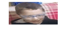 a blurry picture of a young boy wearing glasses