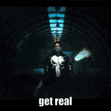 a man in a punisher costume is holding two guns in a tunnel with the words get real below him