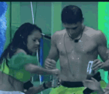 a woman in a green top is standing next to a man in green shorts .