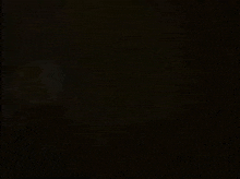 a black background with a blurred image of a person standing in the dark .