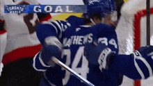 a hockey player with the number 34 on his back is hugging another player