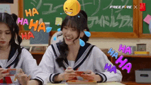 two girls are laughing in front of a blackboard that says free fire x