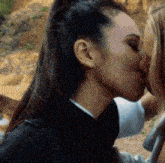 a woman is kissing another woman on the nose