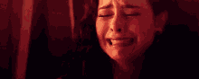 a woman is crying in a dark room while holding a baby .