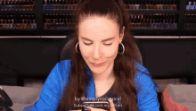 a woman in a blue jacket is looking at her phone with a caption that says simplynaillogical