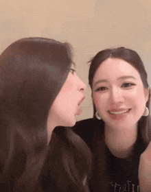 two women are looking at each other with one sticking her tongue out