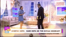 a man and a woman are standing in a living room with a sign that says omoph mera