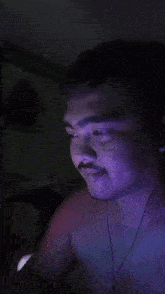 a man without a shirt is wearing headphones and looking down at something