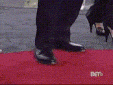 a person standing on a red carpet that says bet on the bottom