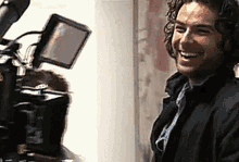 a man is smiling in front of a camera