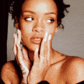 a close up of a woman covering her face with her hands .
