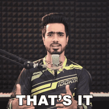 a man standing in front of a microphone with the words that 's it above him