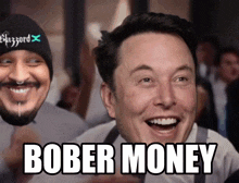 elon musk is smiling in front of a man with a hat that says blizzard on it
