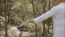 a man in a white coat is pointing a gun at a target