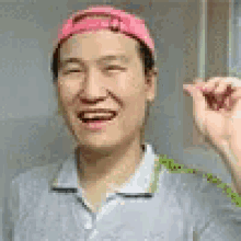 a man wearing a pink hat and a gray shirt is laughing .