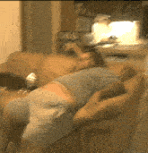 a blurry picture of a man laying on a brown couch