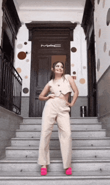 a woman standing on stairs in front of a door that says mac