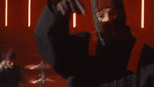 a close up of a man 's face with his hands folded in prayer in a dark room .