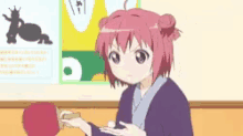 a girl with red hair is sitting at a table eating food