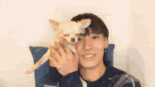 a man is holding a small dog in his arms