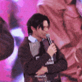 a man is holding a microphone and wearing a shirt that says " balls " on it