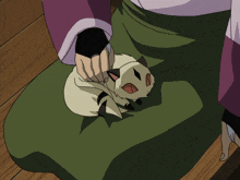 a person holding a small white cat with a black nose