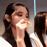 a girl with a ring on her finger is eating a piece of food