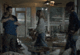 a family hugging in a screened in porch with a ceiling fan