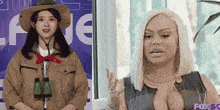 a woman in a cowboy hat stands next to a woman in a fox sg shirt