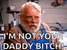 an older man with a beard is sitting in a chair and says i 'm not your daddy bitch