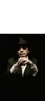 a man in a suit and hat is wearing sunglasses and has his hands folded in front of his face .