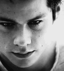 a black and white photo of a young man 's face with a serious look on his face .